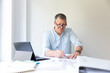 © epiximages - Business portrait of architect sitting at his work table and planning in his modern bright office
