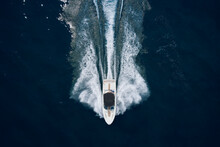 White Boat With A Black Awning Movement On The Water Drone View. Speedboat On Dark Water Aerial View. Boat Trip At Sea.
