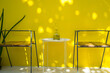 Modern pair of chairs with white round center table in front of the yellow wall that have sunshiny in the living room.