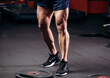 © VlaDee - Healthy Young Man Standing Strong in the Gym and Flexing Legs Close Up