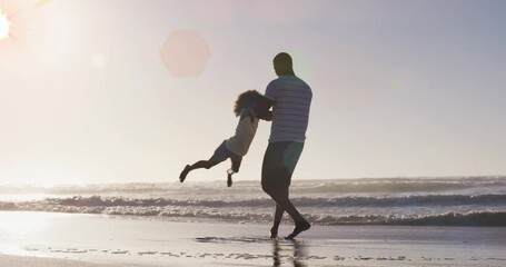 Wall Mural - Animation of spots over happy african american father with daughter on sunny beach