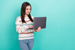 © deagreez - Photo of adorable sweet woman wear striped sweater typing modern device empty space isolated turquoise color background