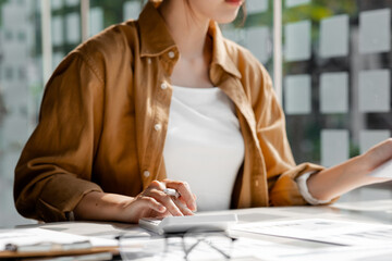 Wall Mural - A business finance woman is reviewing a company's financial documents prepared by the Finance Department for a meeting with business partners. Concept of validating the accuracy of financial numbers.