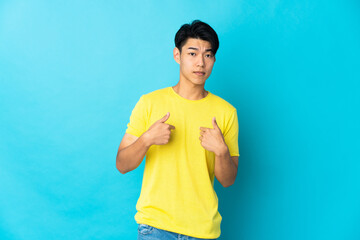 Wall Mural - Young Chinese man isolated on blue background pointing to oneself