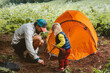 © EVERST - Camping family vacations child helps father to set tent travel lifestyle hiking gear tourism outdoor adventure trip