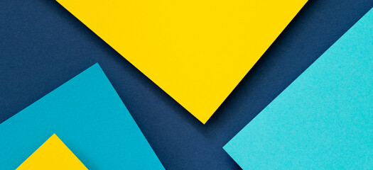 Wall Mural - Abstract color papers geometry flat lay composition banner background with blue and yellow tones