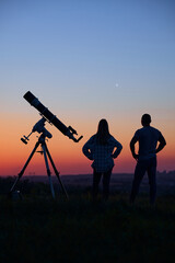 Wall Mural - Couple stargazing together with a astronomical telescope.