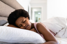 Mid Adult African American Woman Sleeping On Bed At Home