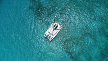 Beautiful Sailing Catamaran At Anchor. Aerial View Of A Yacht In Clear Turquoise Water In The Indian Ocean. Yachting And Travel Concept