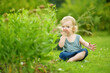 © MNStudio - Silly toddler boy putting soil in his mouth while playing outdoors on sunny summer day. Curious child exploring nature.