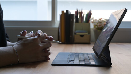 Wall Mural - Young woman studying online, watching webinar on computer tablet. Close up view.