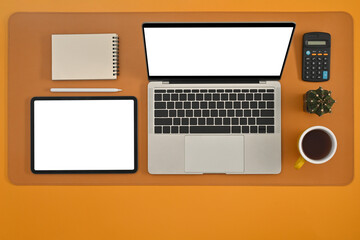 Poster - Top view of laptop computer, digital tablet, calculator, cup of coffee, cactus and note on the yellow background, flat lay composition.