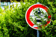 schowany znak drogowy za krzakami z zakazem wjazdu dla aut i motocykli