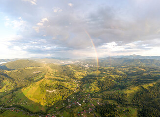 Wall Mural - Aerial drone view. Rainbow in the mountains of the Ukrainian Carpathians.