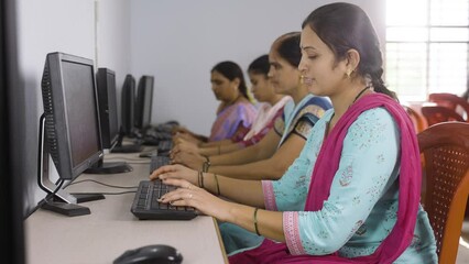 women working on laptop with showing thumbs up by looking at camera during computer training class - concept of learning, successful and development