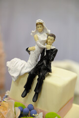 Wall Mural - Vertical closeup shot of newlyweds figurines on a wedding cake