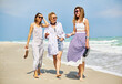 © Oksana Klymenko - Three women are walking on the sand of the beach. They talk, enjoy the seashore. Friendship and summer time concept.