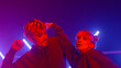 © stockbusters - Stylish couple dancing freestyle together in ultraviolet backlit close up.
