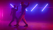 © stockbusters - Cool couple dancing playfully in nightclub. Stylish dancers moving body on stage