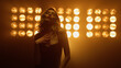 © stockbusters - Hot woman walking towards camera in spotlights. Blonde lady posing seductive.