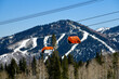 Orange bubble chair lift at Park City Canyons Ski Area in Utah. Late spring weather conditions. Background view to the mountains with ski slopes.