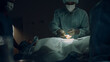 © stockbusters - Nurse handling sterile instruments dark room closeup. Medical team cooperation