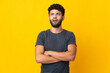 © luismolinero - Young Moroccan man isolated on yellow background looking up and with surprised expression
