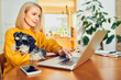 © baranq - Mid adult woman using laptop at home office sitting with dog at a table