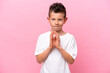 Little caucasian boy isolated on pink background scheming something