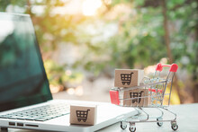 Shopping Online. Cardboard Box With A Shopping Cart Logo In A Trolley On Laptop Keyboard. Shopping Service On The Online Web. Offers Home Delivery.