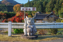 Traditional Japanese Patronus Statue In The Street: Rock Demon And Road Sign