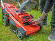 Male Gardener changing the Lithium Ion battery on a electric cordless lawnmower