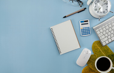 Poster - Blank notebook with pen are on top of computer keyboard over white office desk table with office supplies. Top view with copy space, flat lay