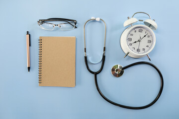 Poster - Stethoscope and notebook, Office desk with computer, Pen, eyeglass, notebook, Cup of coffee on white background, Top view with copy space, Mock up.