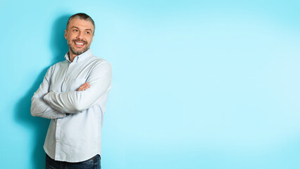 Poster - Middle Aged Man Posing Looking Aside Over Blue Background, Panorama