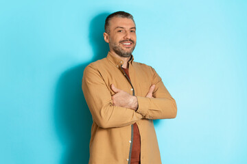 Poster - Handsome Middle Aged Man Standing Posing Over Blue Studio Background