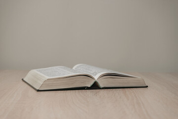 Aufkleber - Open holy bible on a  wooden table. Beautiful white wall background.