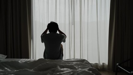 Lonely young man feeling depressed and stressed sitting in the dark bedroom, Negative emotion and mental health concept