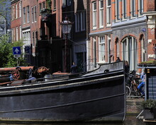Amsterdam Tuinstraat Street View With Boat, House Facades, Vintage Lamp Post And Walking Man, Netherlands