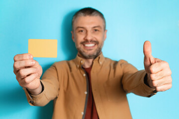 Poster - Man Showing Credit Card And Like Standing Over Blue Background