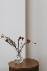 Wall Mural - Dried pampas grass and flowers bouquet in glass vase on wooden side table against white wall. Aesthetic minimalist home living room interior design decoration details. Elegant luxury apartment decor