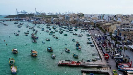 Sticker - Aerial 4K panoramic footage of Marsaxlokk - small, traditional fishing village in the South Eastern Region of Malta with many colorful fisherman boats in the bay