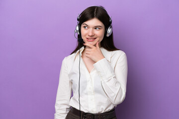 Wall Mural - Telemarketer Russian woman working with a headset isolated on purple background looking to the side