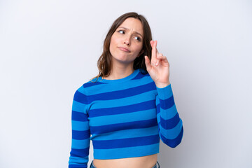 Young caucasian woman isolated on white background with fingers crossing and wishing the best