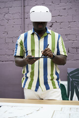 Poster - Portrait of African graphic designer using virtual reality goggles to use graphic tablet while standing at office