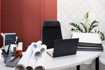 Poster - Workplace of architect with laptop, folders and blueprints on table at modern office