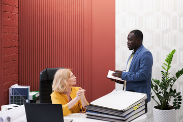 Poster - African businessman talking to manager and making notes in notebook during their conversation at office
