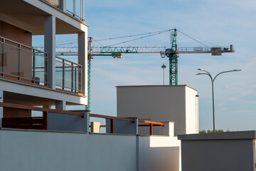 Wall Mural - Construction crane among modern residential buildings on a sunny day