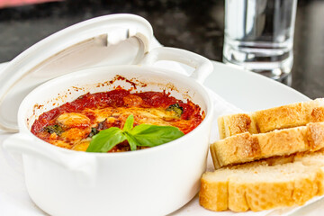 Wall Mural - Beef stew with potatoes and carrots in tomato sauce in red pot, gray background. Slow cooking concept