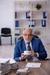 © Elnur - Old male employee drinking coffee during break